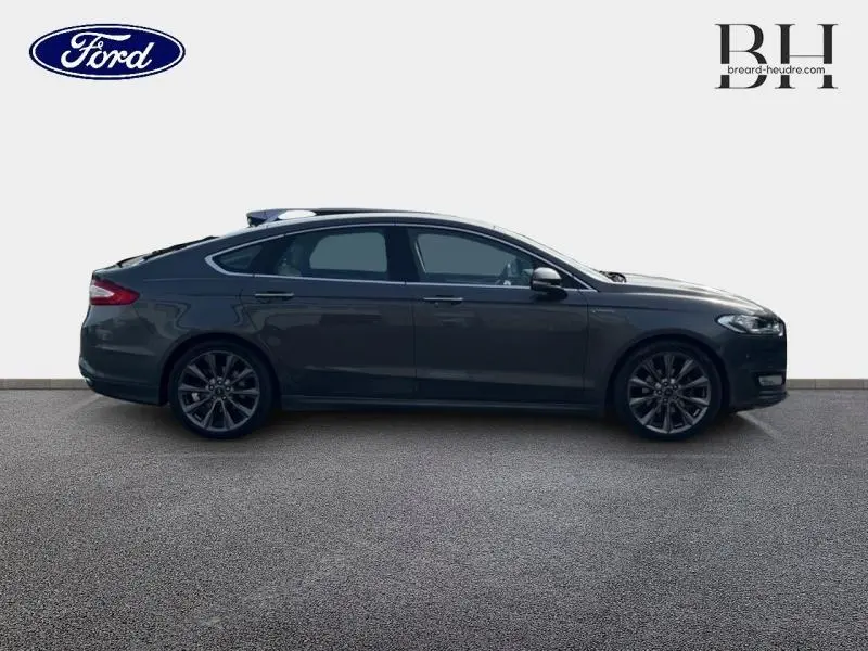 Profil droit d'une Ford Mondeo 2018 gris Magnetic avec jantes alliage foncé et vitres teintées sur fond clair.