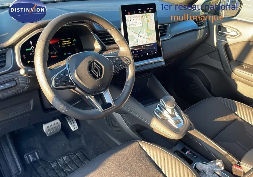 Intérieur avant du Renault Captur E-Tech hybride 2025, tableau de bord moderne avec écran tactile vertical et volant multifonction.