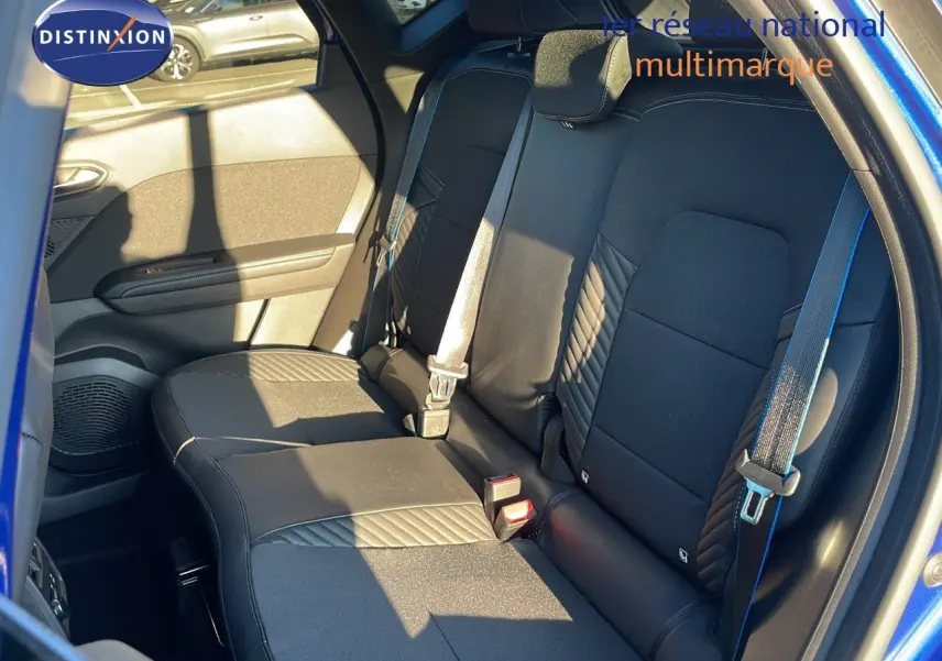 Vue intérieure arrière sur les sièges noirs avec surpiqûres bleues du Renault Captur E-Tech hybride 2025 toit noir.