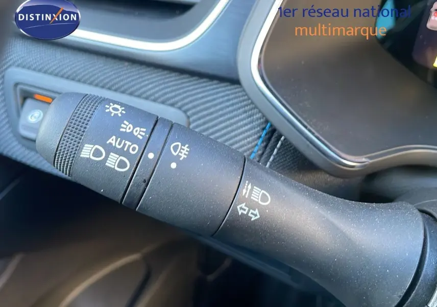 Gros plan sur la commande des feux et clignotants du Renault Captur E-Tech hybride 2025, intérieur noir texturé.