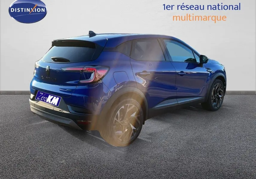Renault Captur E-Tech hybride bleu Iron Metal avec toit noir, vue 3/4 arrière côté gauche, jantes noires distinctives.