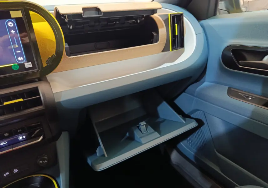 Intérieur FIAT Grande Panda 1.2 Hybrid 2025 côté passager, boîte à gants ouverte, tableau de bord bleu et beige.