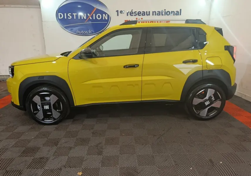 Vue de profil côté gauche d'une FIAT Grande Panda jaune 2025 avec jantes noires et marquage "PANDA" sur la porte.