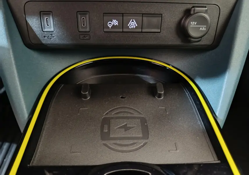 Gros plan sur la zone de recharge sans fil entourée de jaune dans l’habitacle de la Fiat Grande Panda 1.2 Hybrid 2025.