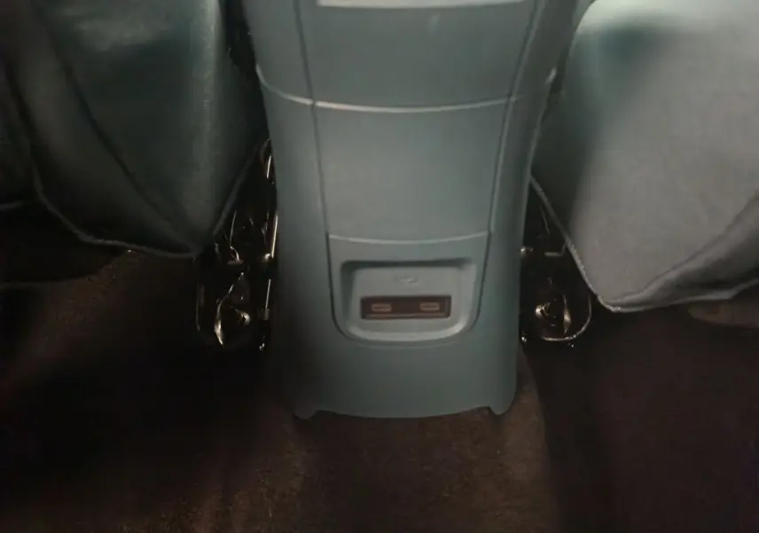 Vue rapprochée de la console centrale arrière grise avec ports USB dans l’habitacle de la Fiat Grande Panda jaune.