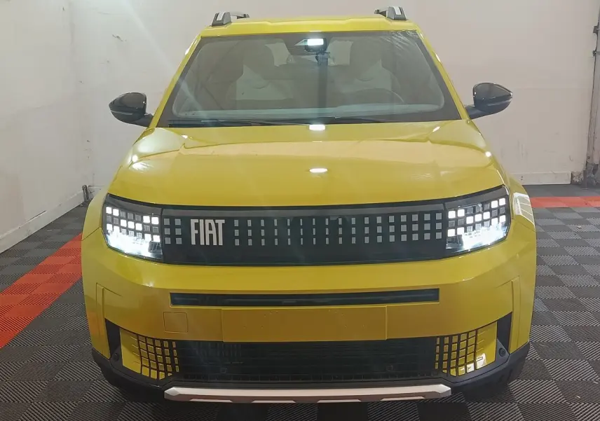 Vue avant d'une FIAT Grande Panda jaune 2025 avec phares LED et calandre pixelisée distinctive.