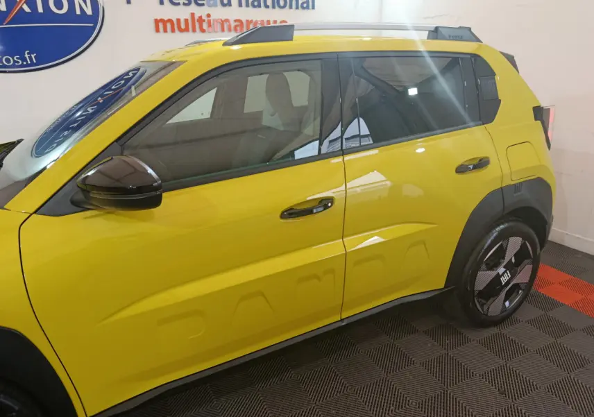 Vue de profil côté gauche d'une FIAT Grande Panda jaune avec détails de carrosserie et jantes noires.