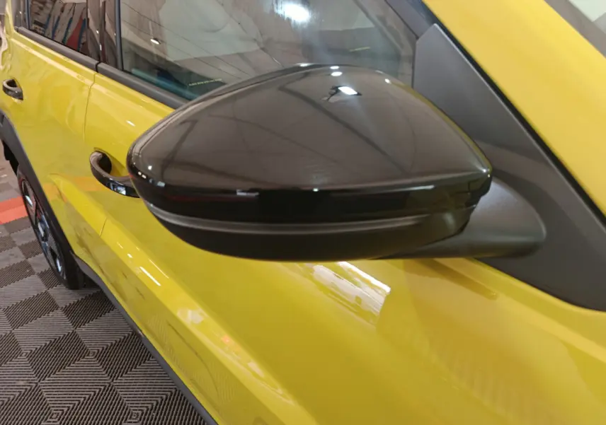 Gros plan sur le rétroviseur noir côté conducteur d’une FIAT Grande Panda jaune 2025 vue de profil gauche.