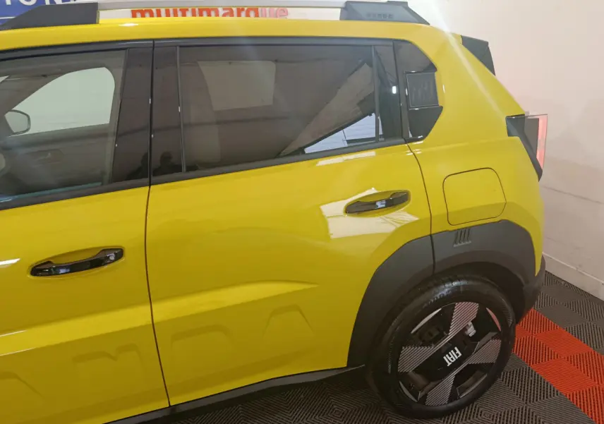 Vue latérale droite de la FIAT Grande Panda jaune 2025 avec jantes noires et détails de carrosserie marqués.