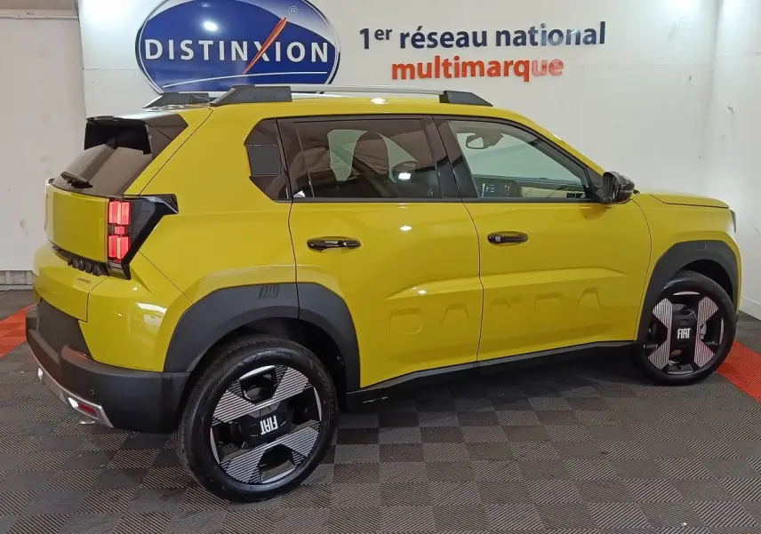 Vue côté droit arrière d'une FIAT Grande Panda 1.2 Hybrid jaune avec jantes noires au design graphique et toit noir.