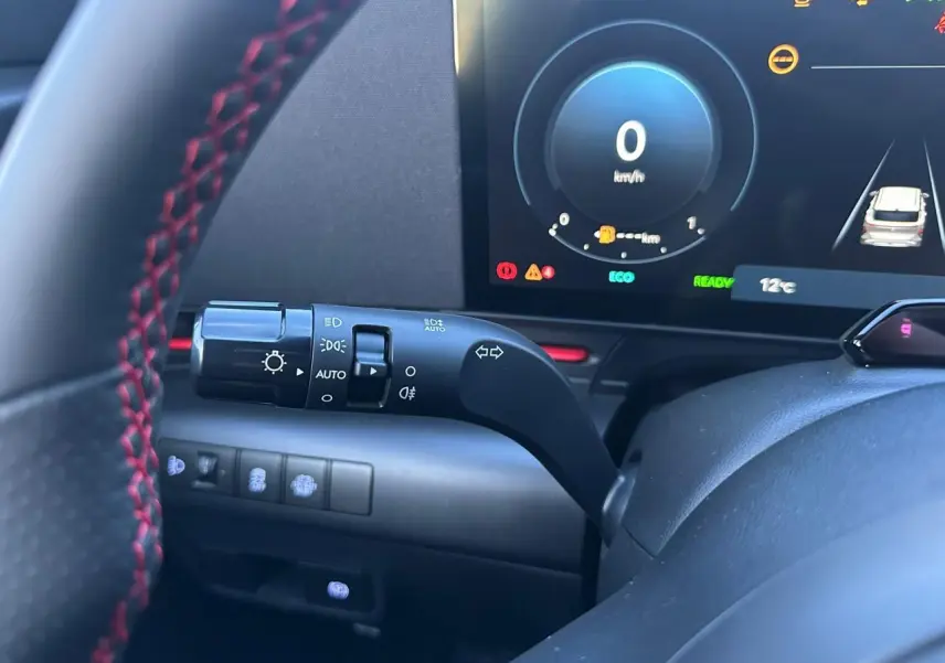 Vue rapprochée du combiné d'instruments et du commodo gauche du Hyundai KONA 2025 noir, affichage numérique et volant cuir.