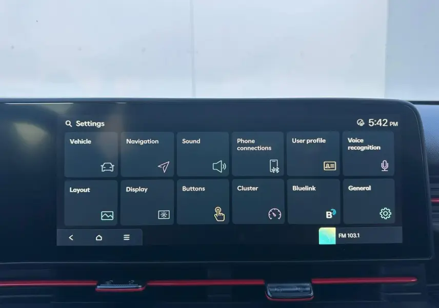 Écran tactile central du Hyundai Kona 2025 affichant le menu des réglages avec interface sombre et accents rouges.