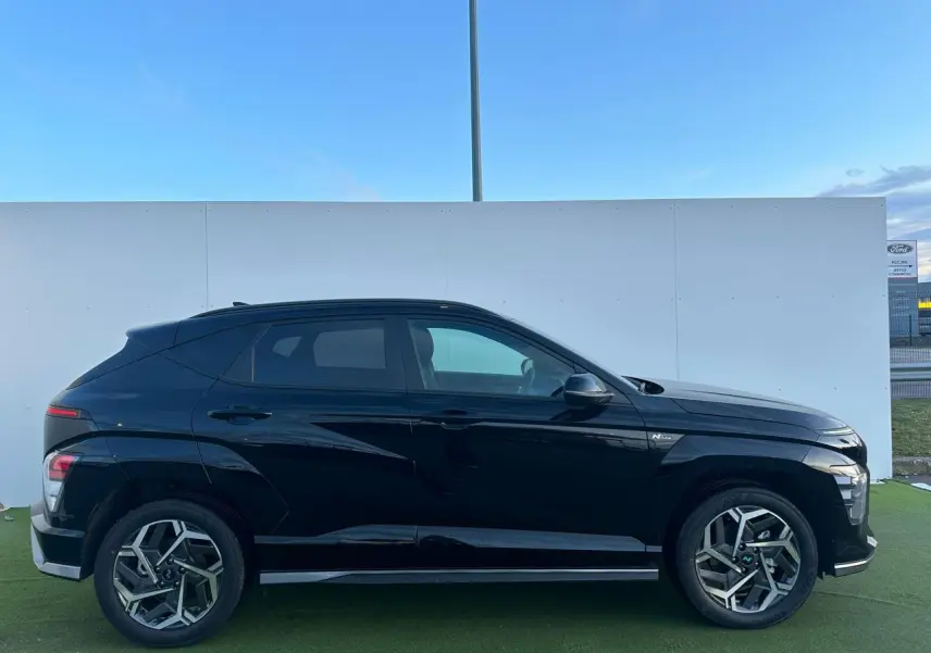 Profil droit du Hyundai KONA II noir Abyss Metal 2025 avec jantes alliage 18 pouces et vitres surteintées.