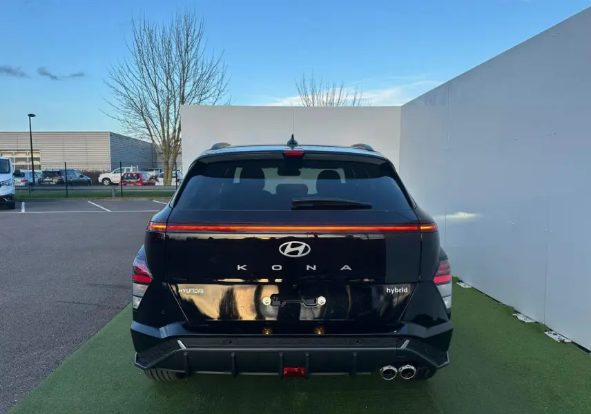 Vue arrière du Hyundai Kona II noir Abyss Metal avec feux LED continus et double sortie d'échappement chromée.