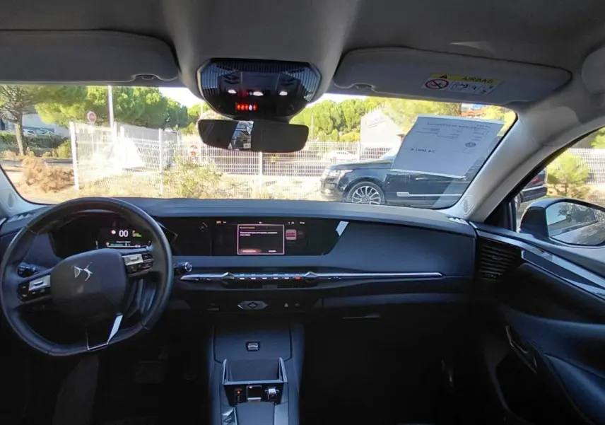 Vue intérieure avant du DS4 Hybride E-Tense gris 2024, avec tableau de bord digital et écran tactile central.
