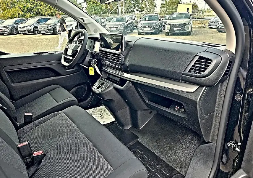 Vue intérieure côté conducteur du Fiat Scudo Combi noir 2026, montrant tableau de bord et banquette avant bi-ton noir/gris.
