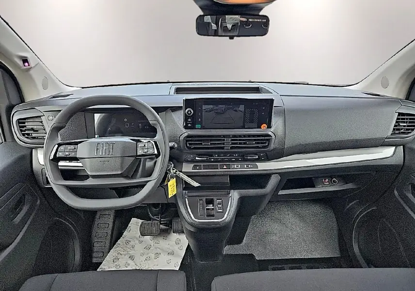 Tableau de bord noir du Fiat Scudo Combi 2026 vu de face, avec volant multifonction et écran tactile central.