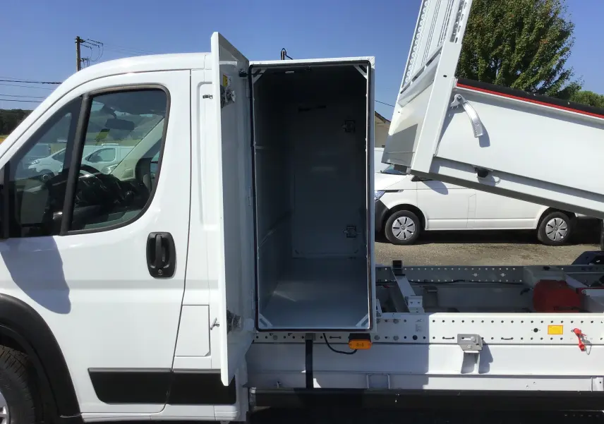 Vue latérale gauche du FIAT Ducato Chassis Benne blanc 2023 avec coffre ouvert et benne acier relevée