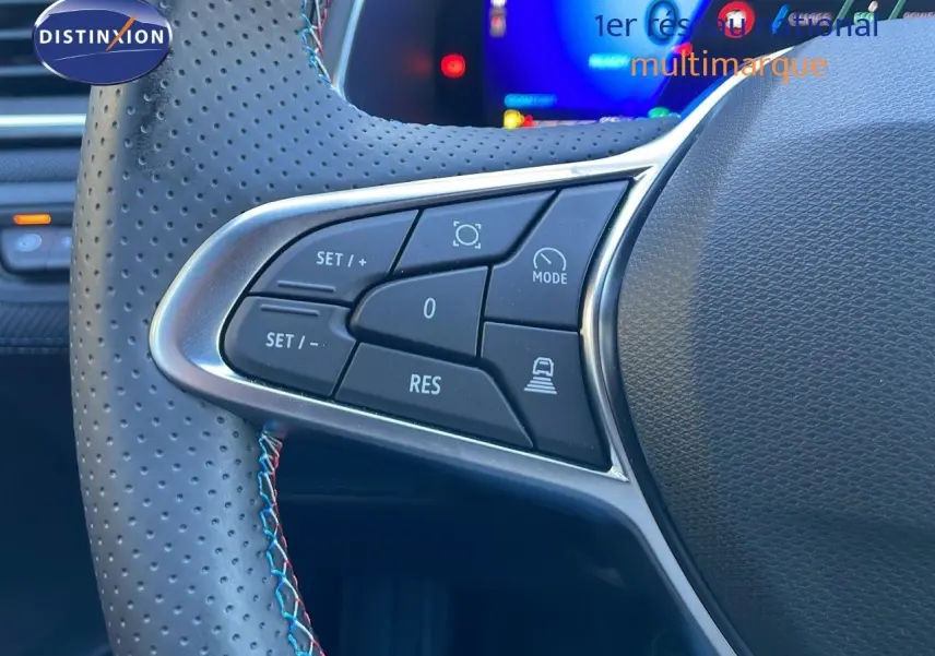 Gros plan sur les commandes du volant en cuir perforé avec surpiqûres tricolores du Renault Symbioz bleu Iron Metal.