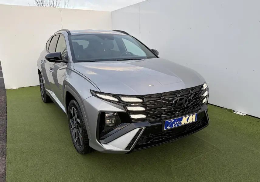 Hyundai Tucson 2025 hybride N Line en Shimmering Silver, vue 3/4 avant avec calandre noire distinctive.