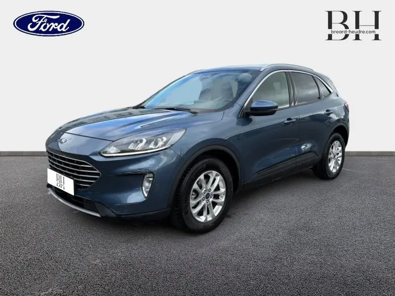 Ford Kuga bleu azur métallisé en vue 3/4 avant droit, avec jantes alu et vitres arrière surteintées.