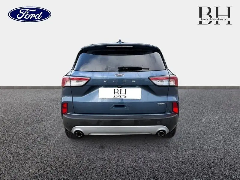 Vue arrière d'un Ford Kuga 2022 bleu azur métallisé avec double sortie d'échappement et vitres arrière surteintées.