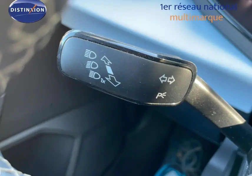 Gros plan sur la manette de clignotant du SEAT Arona 2025, intérieur gris noir avec détails de commandes lumineuses.