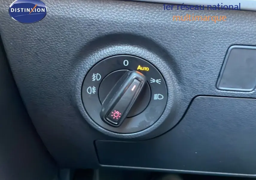 Gros plan sur le bouton de commande des phares du tableau de bord d’un SEAT Arona blanc métal toit noir 2025.