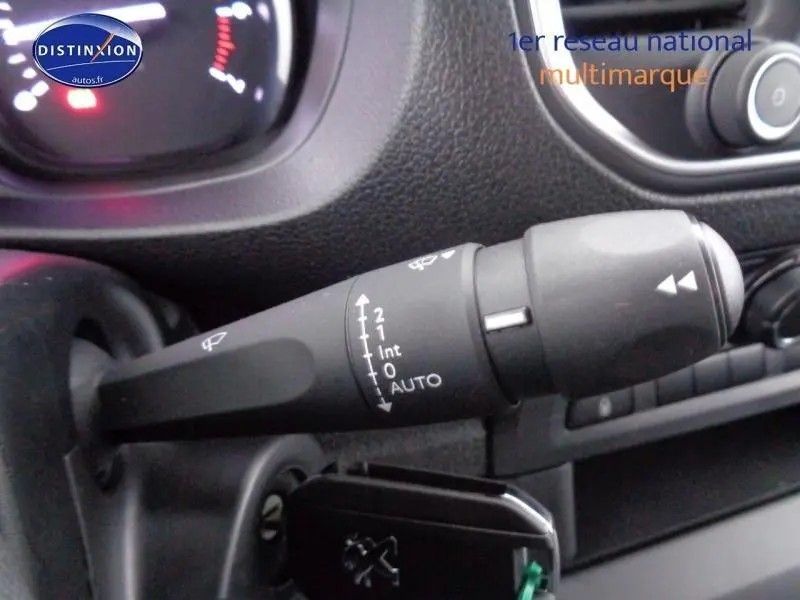 Gros plan sur la commande d'essuie-glace du Peugeot Expert Fourgon gris acier, avec tableau de bord en arrière-plan flou.