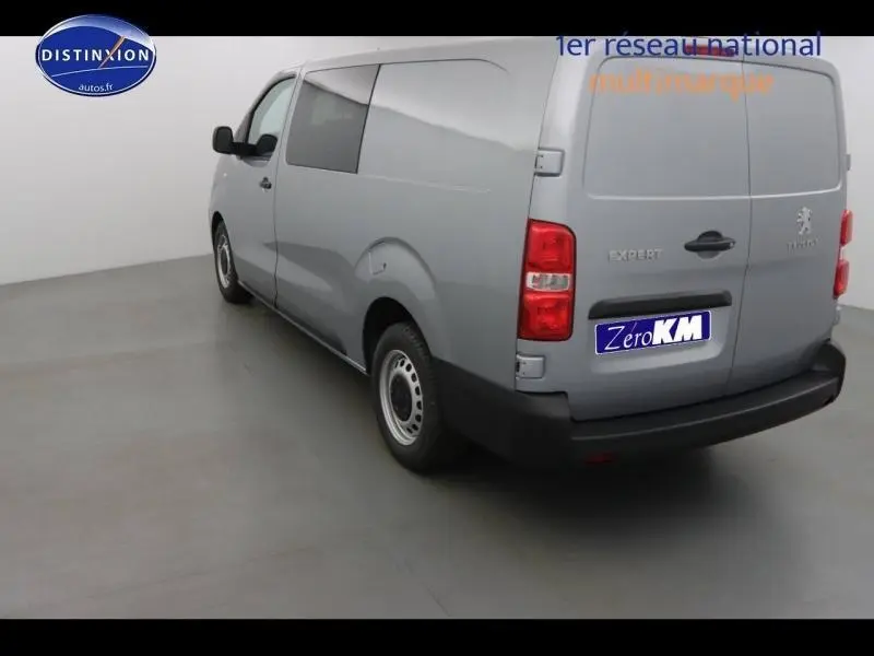 Vue 3/4 arrière droite d'un Peugeot Expert Fourgon gris acier métal avec double portes arrière et vitre latérale fixe.
