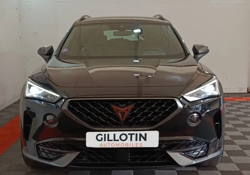 Vue frontale d'un CUPRA Formentor noir 2024 avec feux LED allumés et calandre distinctive au logo cuivré.