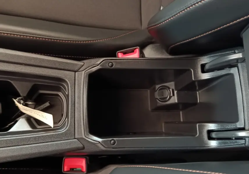 Vue plongeante sur le rangement central noir avec prise 12V et coutures orange du CUPRA Formentor 1.4 e-HYBRID 2024.