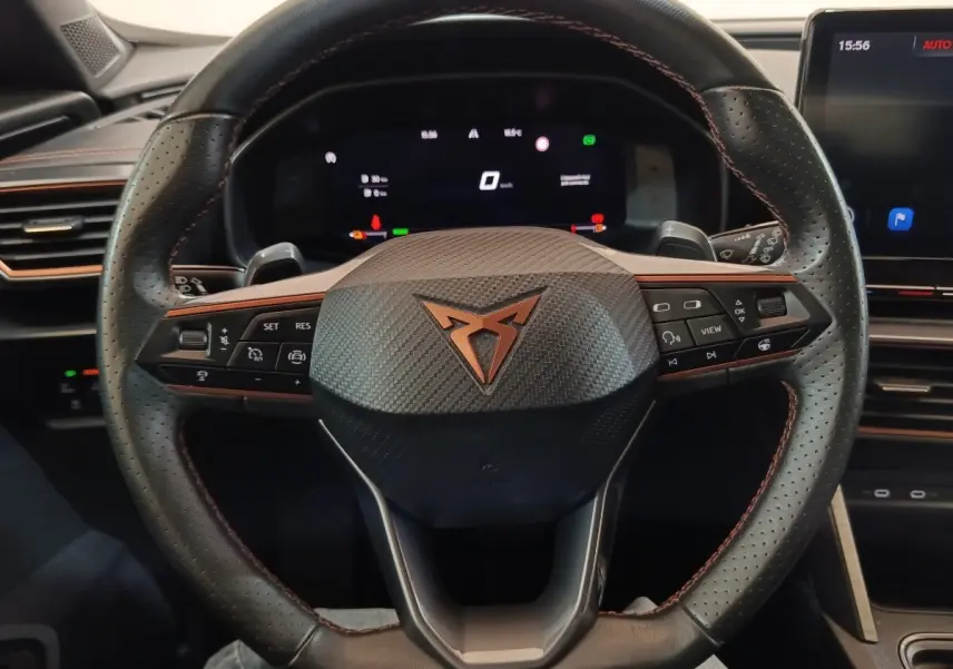 Vue rapprochée du volant noir perforé avec logo Cupra cuivré et tableau de bord numérique du Formentor 2024.