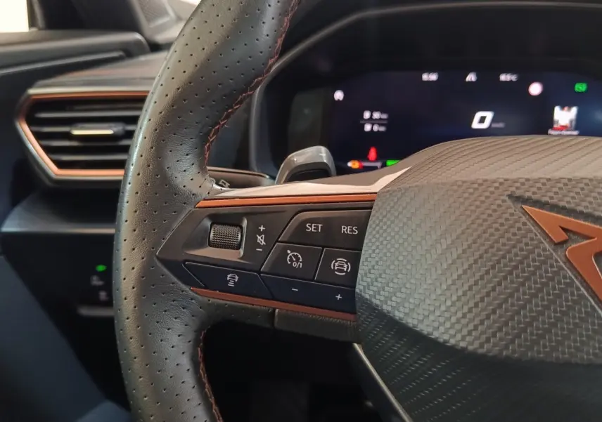 Gros plan sur le volant noir perforé avec surpiqûres cuivrées et commandes multifonctions du CUPRA Formentor 2024.