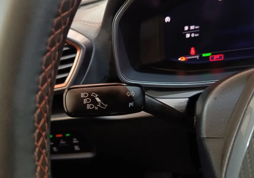 Gros plan sur la manette de clignotants noire à gauche du volant du tableau de bord du CUPRA Formentor noir 2024.