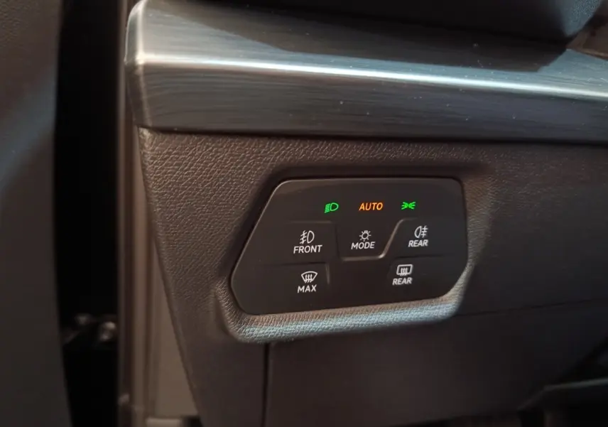 Gros plan sur les commandes d’éclairage et désembuage du tableau de bord noir du CUPRA Formentor 2024.