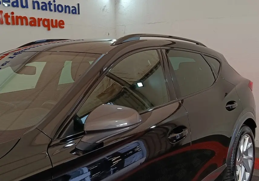 Vue de côté gauche rapprochée du CUPRA Formentor noir 2024 avec rétroviseur ton caisse et rails de toit visibles.