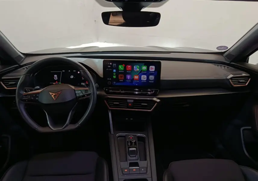 Vue intérieure frontale du tableau de bord noir du CUPRA Formentor 1.4 e-HYBRID avec écran tactile central allumé.