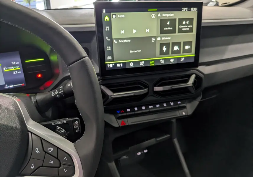Vue intérieure du tableau de bord du Dacia Duster Hybrid-G 150 CH avec écran tactile et commandes au volant.