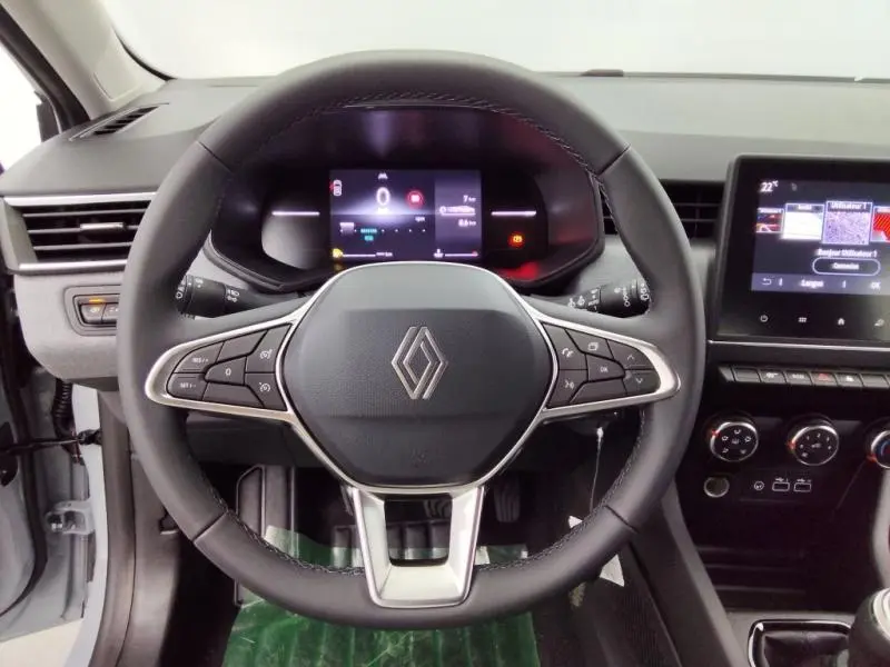 Vue frontale du volant multifonction noir de la Renault Clio 1.5 dCi 2025 avec tableau de bord digital et écran tactile.