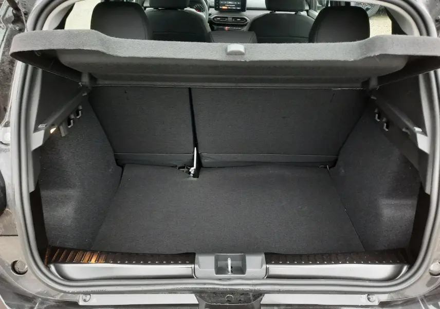 Coffre ouvert vue arrière d'une Dacia Sandero Stepway noir nacré, intérieur tissu gris et banquette rabattable.