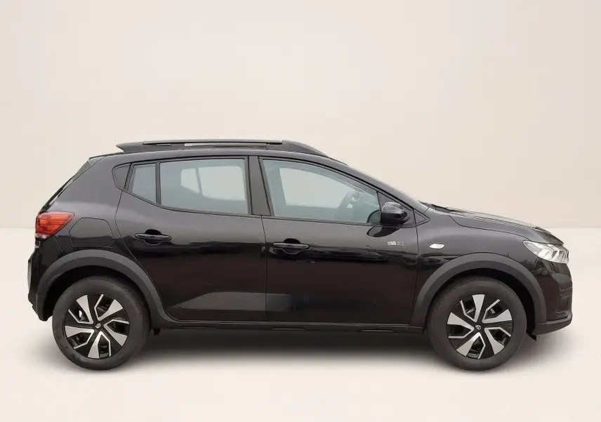 Profil droit de la Dacia Sandero Stepway 2025 noir nacré avec barres de toit et jantes 16 pouces à enjoliveurs.