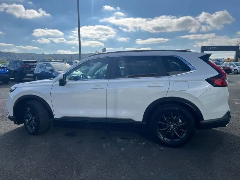 Vue latérale droite d'un Honda CR-V 2024 blanc diamant métallisé avec jantes alliage noires et toit panoramique.