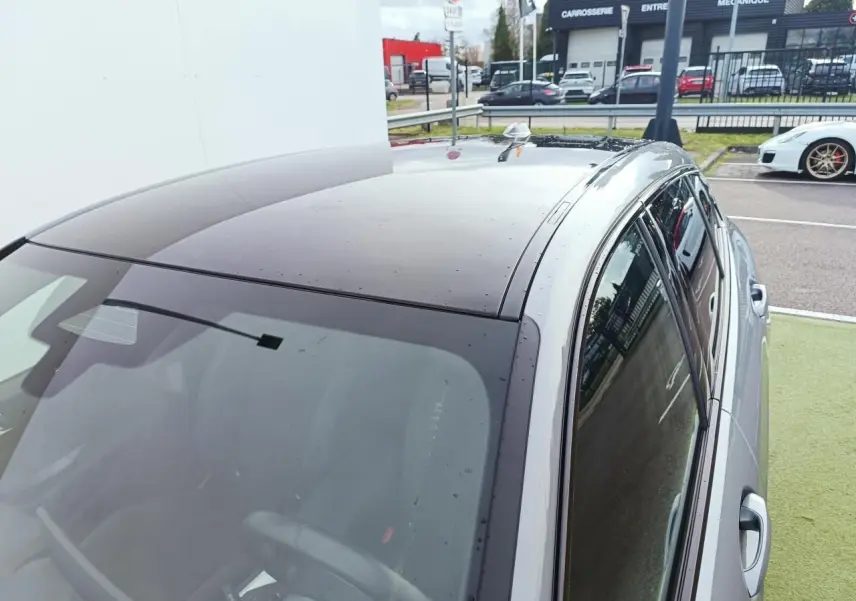 Vue en plongée montrant le toit noir et la carrosserie gris Skyscraper d'une BMW Série 1 F70 côté droit.