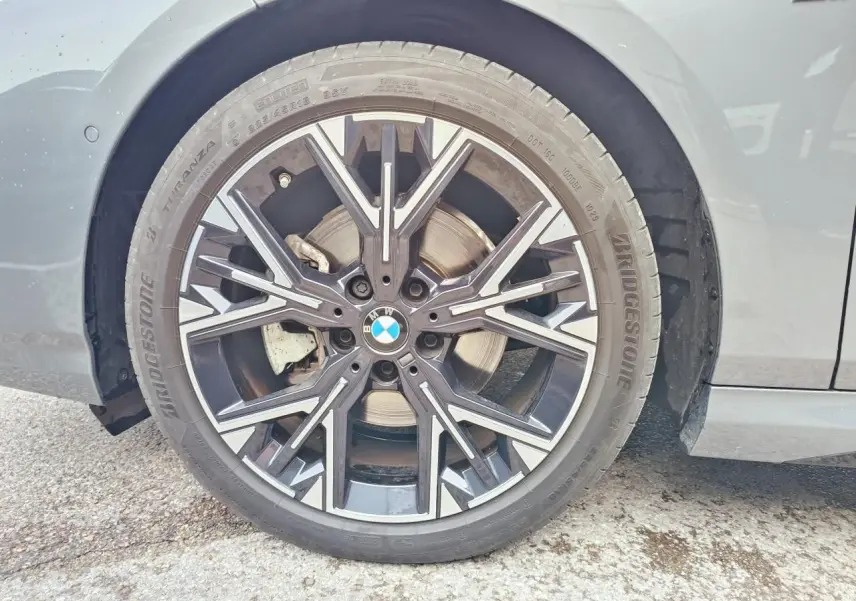 Gros plan sur la roue avant droite de la BMW Série 1 gris Skyscraper avec jante alliage M bicolore et logo BMW au centre.