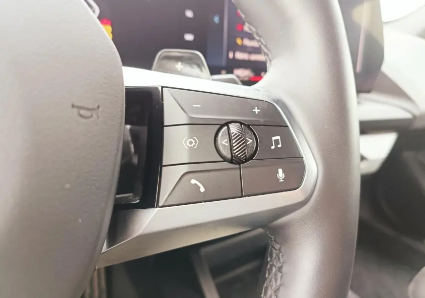 Gros plan sur les commandes multifonctions du côté droit du volant cuir de la BMW Série 1 120 M Sport 2025.