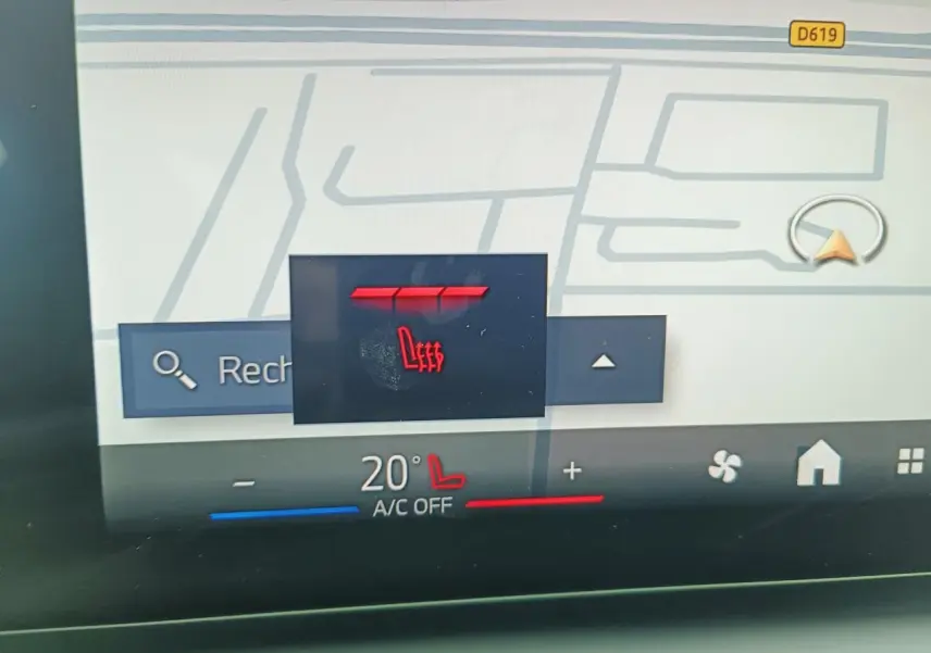 Gros plan sur l'écran tactile intérieur de la BMW Série 1 2025, affichant la commande de siège chauffant rouge.