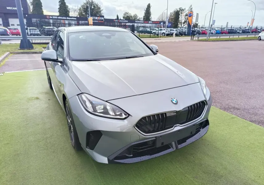 BMW Série 1 F70 gris Skyscraper vue 3/4 avant gauche avec calandre noire et toit noir sur parking.