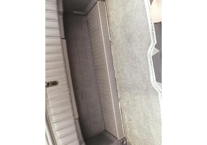 Vue en plongée sur le compartiment de rangement sous le plancher du coffre de la BMW Série 1 F70 120 M Sport gris Skyscraper.