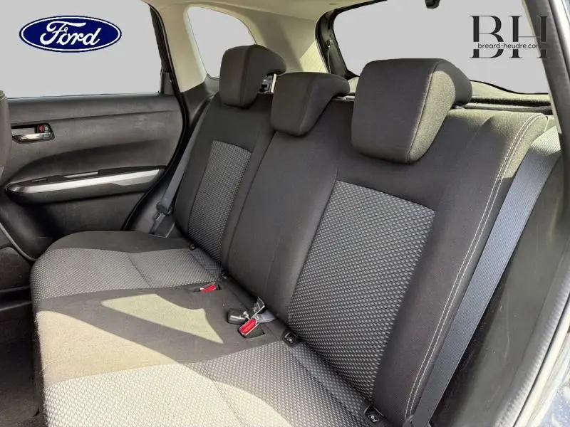 Banquette arrière vue côté droit, sièges tissu noir et gris à motifs, ceintures de sécurité visibles, intérieur lumineux.